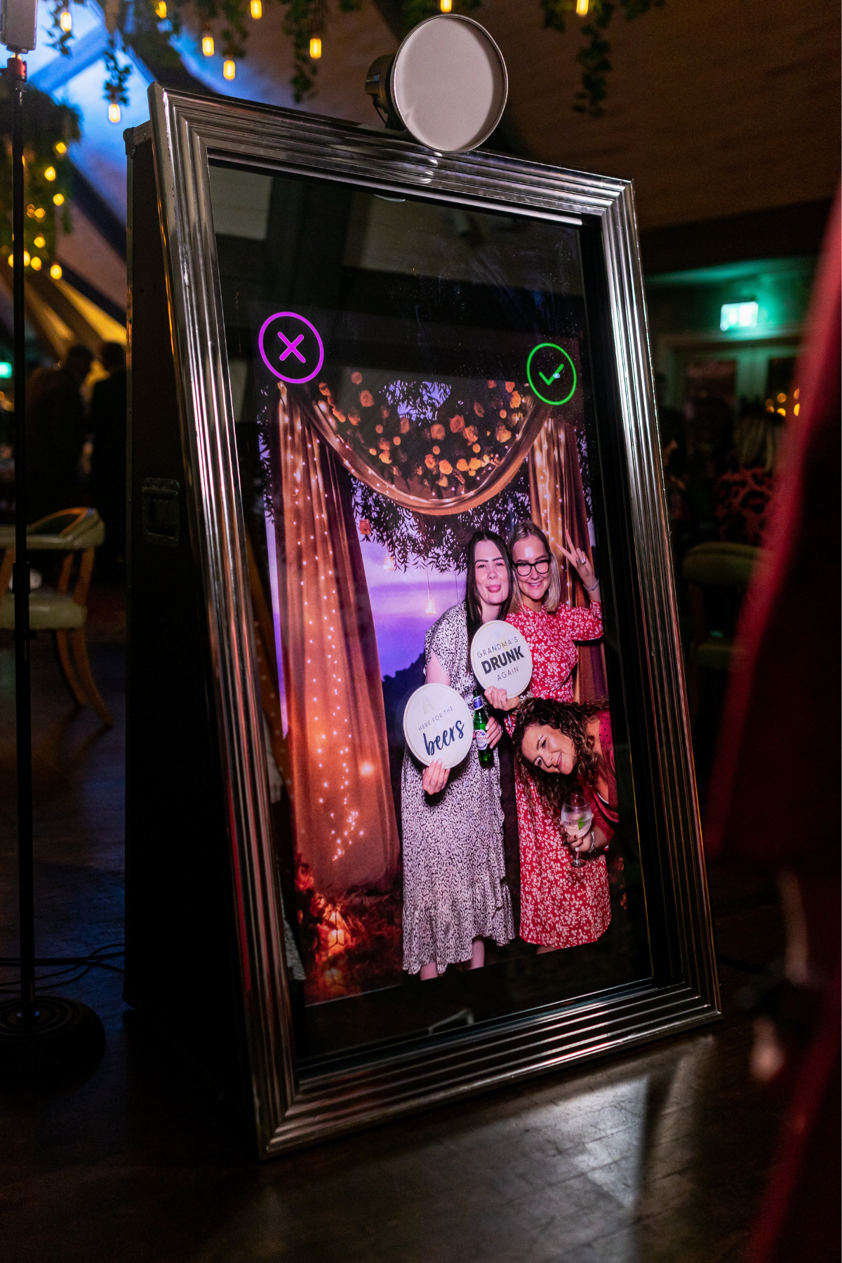 Group of guests posing with props in front of the Magik Mirror Photo Booth