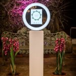 Ring light photo booth with floral background at outdoor garden event