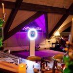 Ring light photo booth illuminated in cozy indoor lounge with purple lighting