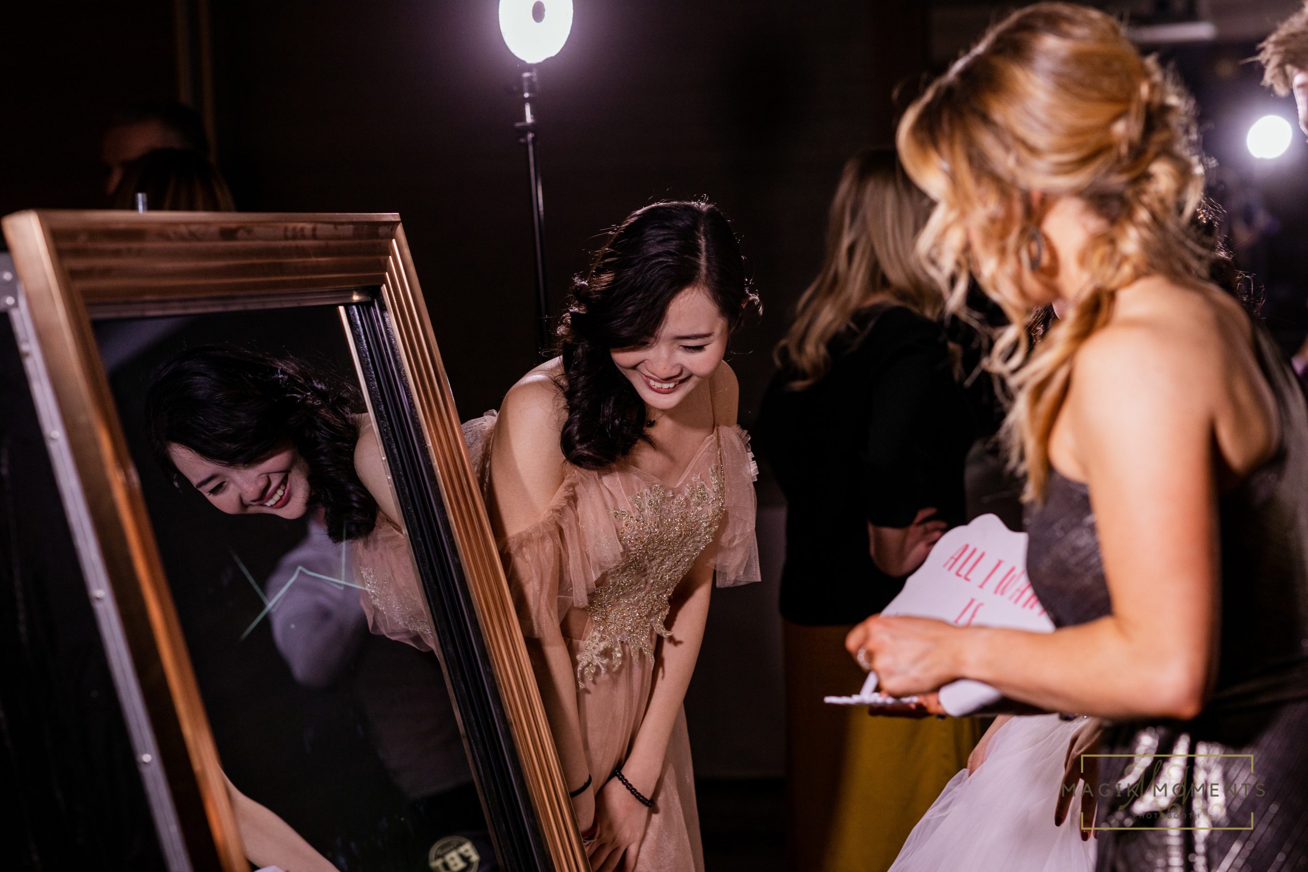 Guest laughing while using Magik Mirror Photo Booth at an event